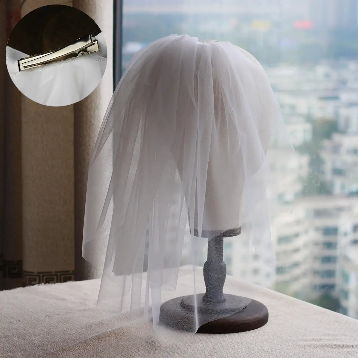 a delicate white tulle retro short wedding veil with lace floral details and a silver clip displayed on a mannequin head as a short wedding bride headdress