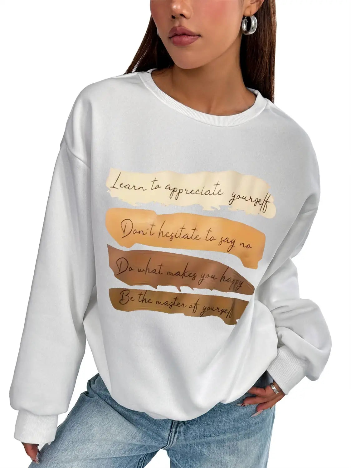 White oversized long sleeve sweatshirt in solid colour featuring motivational quotes printed in brown cursive on layered beige and tan horizontal stripes ideal for daily wear.