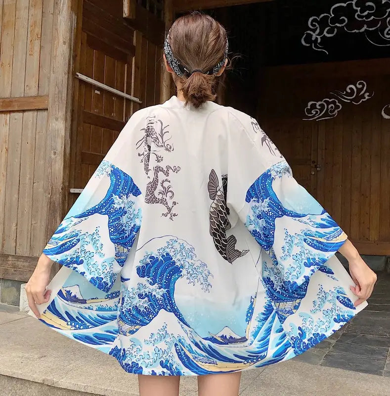 white kimono-style coat sun protection clothing featuring vibrant blue wave and fish pattern inspired by hokusai the great wave off kanagawa with black ink detailing on the back