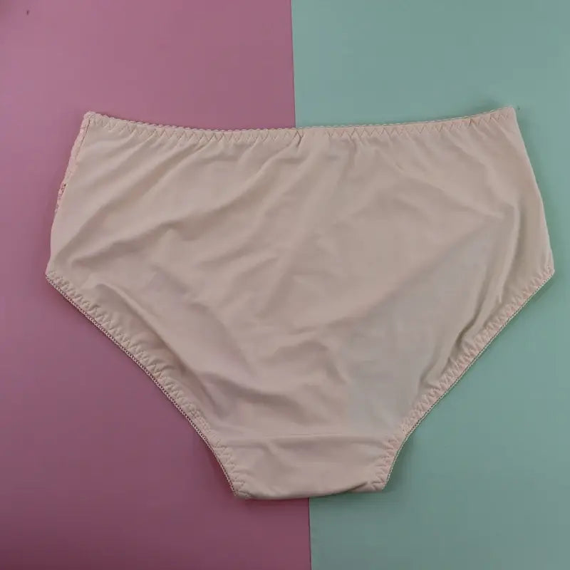 beige cotton briefs with a smooth slightly wrinkled texture and a neatly stitched elastic waistband as part of a plus size underwire lace trim lingerie set