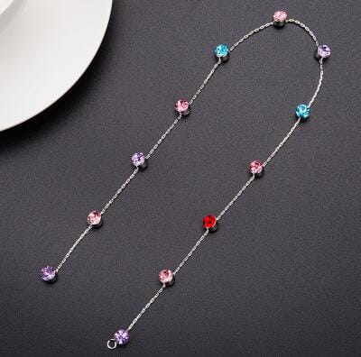 A delicate silver chain necklace with colorful faceted gemstones in pink, blue, red, and purple, designed as beaded pink floral wedding hair accessories for elegant wedding hair.