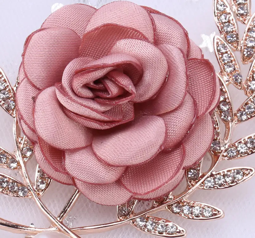 a fabric flower lady temperamental pin featuring a delicate rose-shaped brooch crafted from soft pink satin fabric accented with sparkling rhinestones along a gold-toned leafy frame