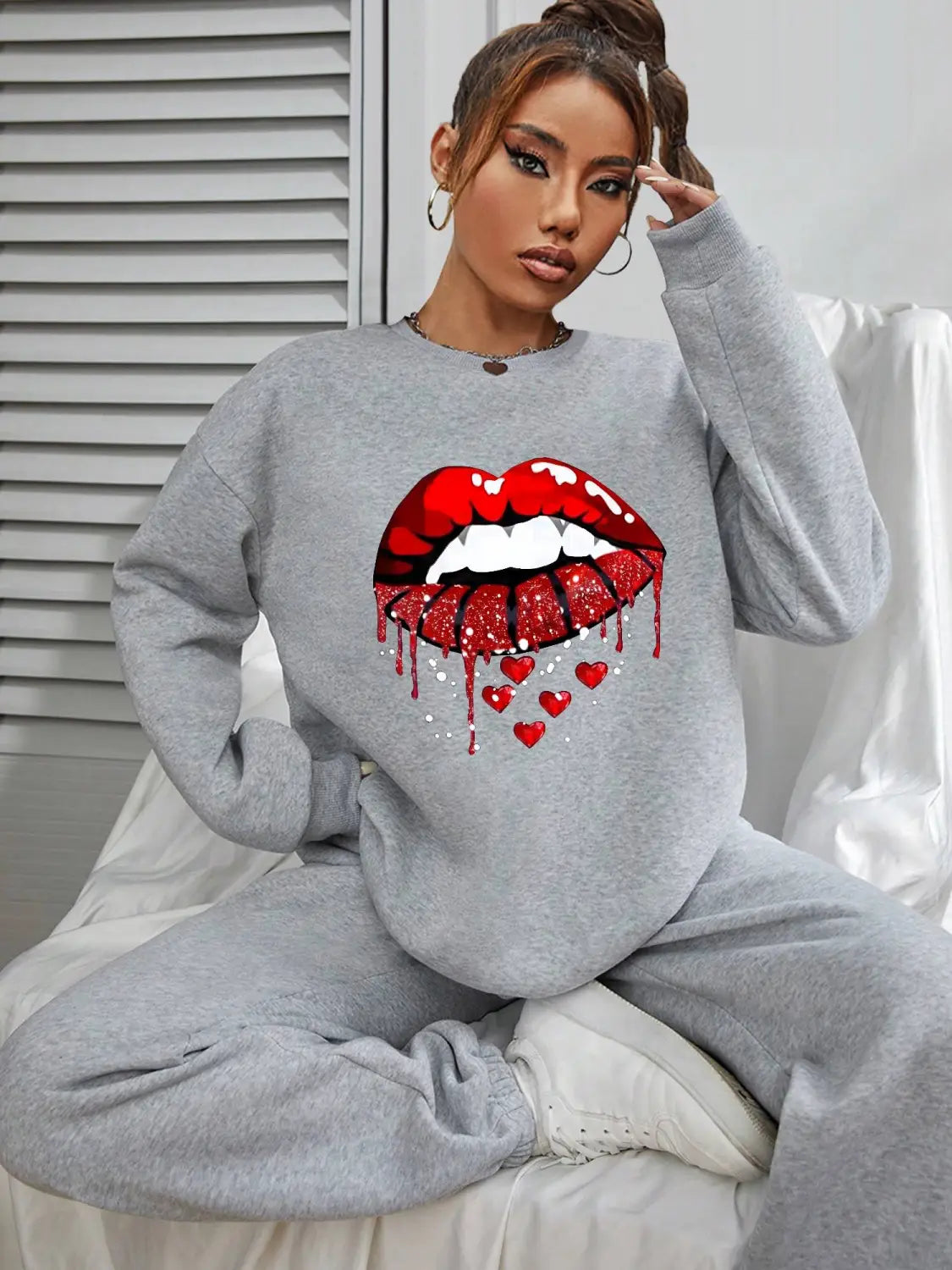 gray pocketed long sleeve sweatshirt featuring a bold red glittery lips graphic with a dripping effect and small hearts below