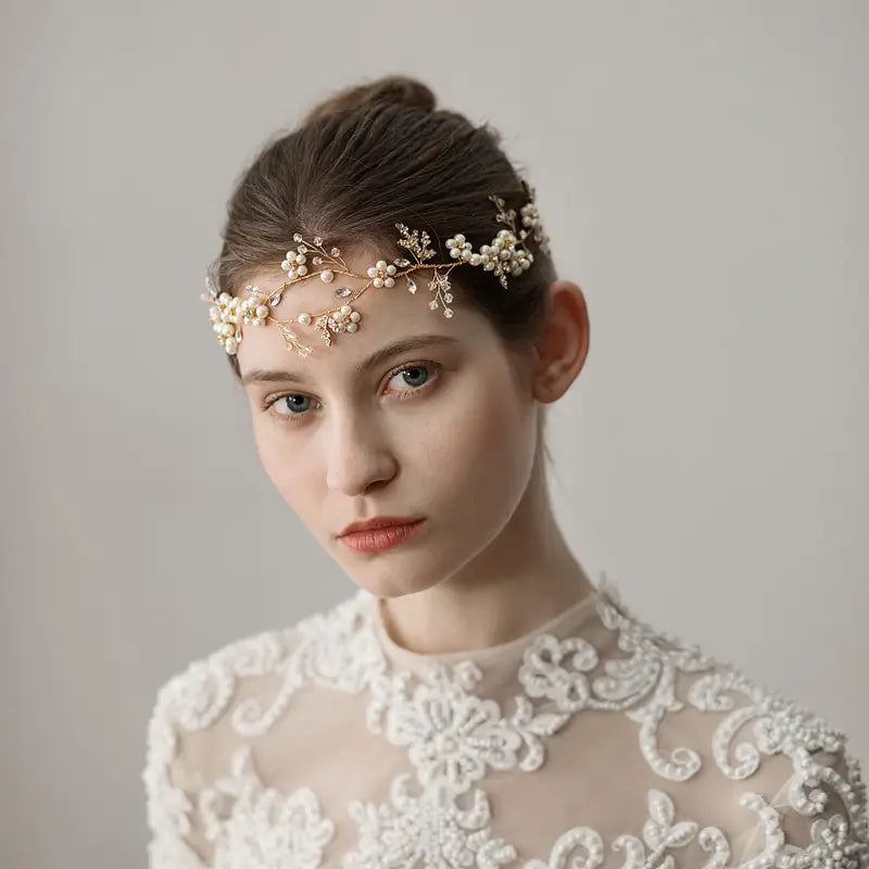 A delicate gold-toned flower wedding headband adorned with small pearls and intricate beadwork worn elegantly across the forehead as pearl flower wedding headband accessories.