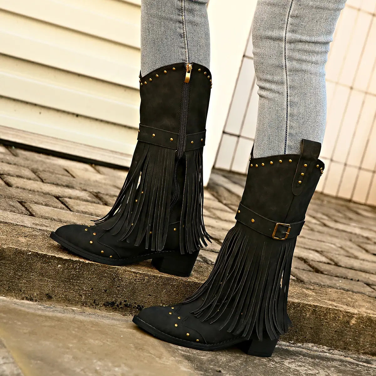 black suede fringed cowboy boots with gold-tone studs buckle accents and fashion square heel for retro winter fashion.