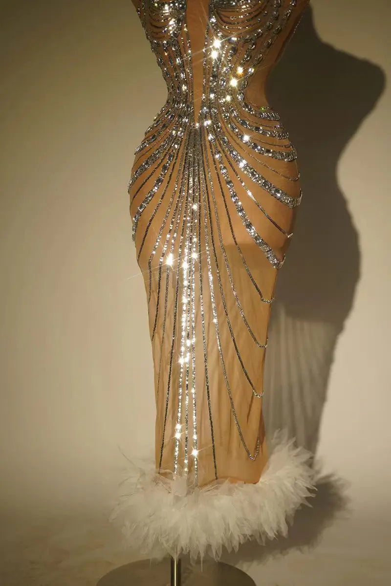 a shimmering skin toned rhinestone feather dress banquet gown featuring intricate silver beading and a fluffy white feather trim at the hem
