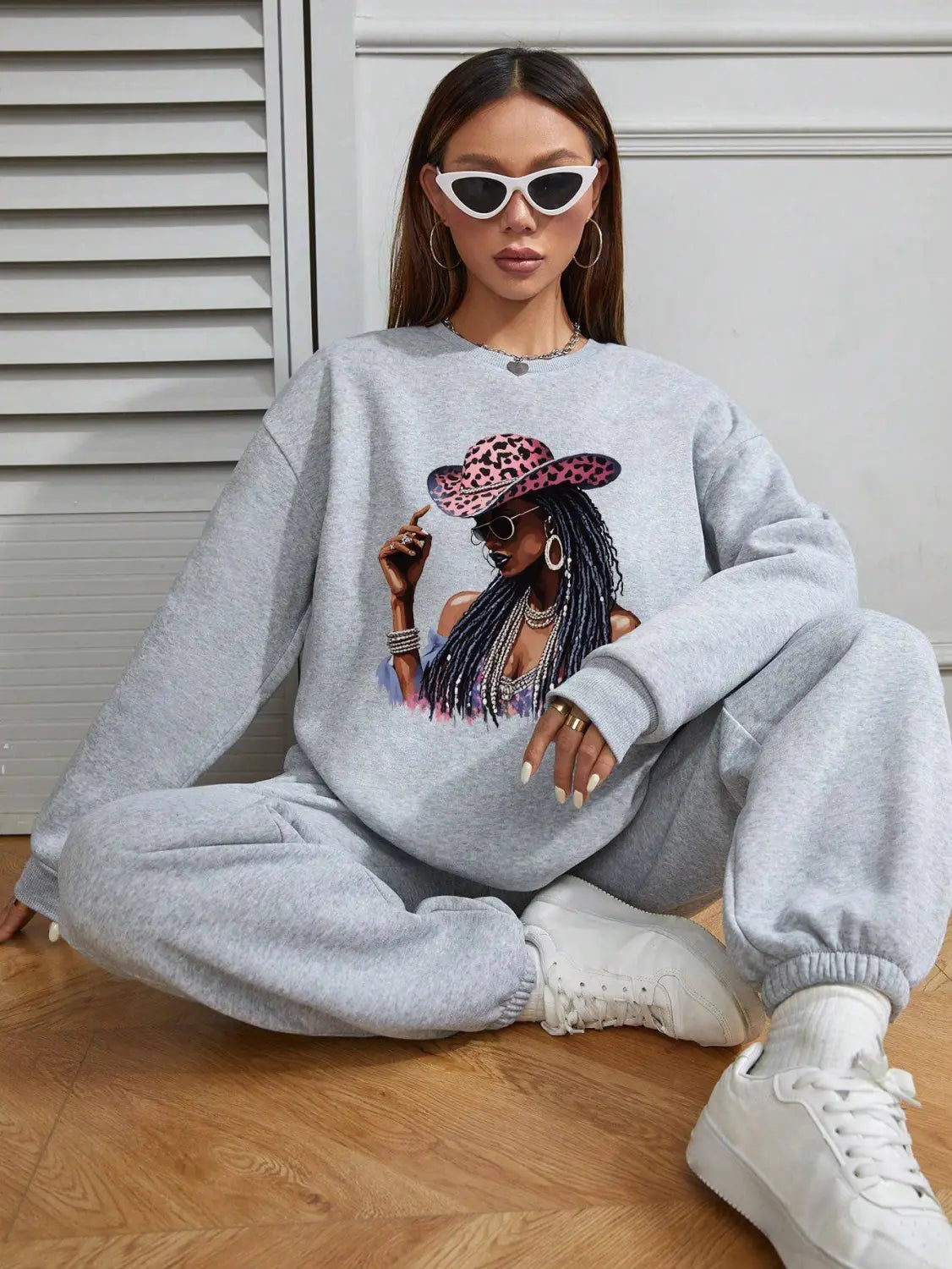 gray oversized long sleeve sweatshirt featuring a vibrant graphic of a woman wearing a leopard-print hat and sunglasses