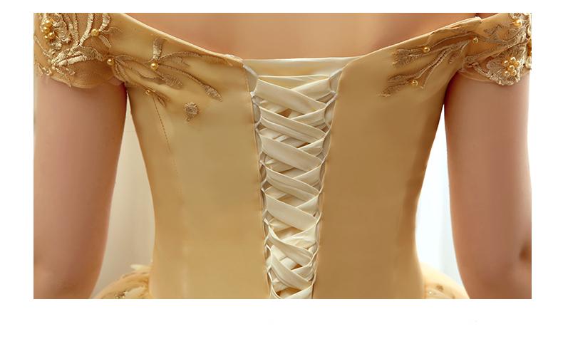 Gold satin off-the-shoulder solo performance costume tutu with intricate embroidered detailing and cream-colored lace-up back.