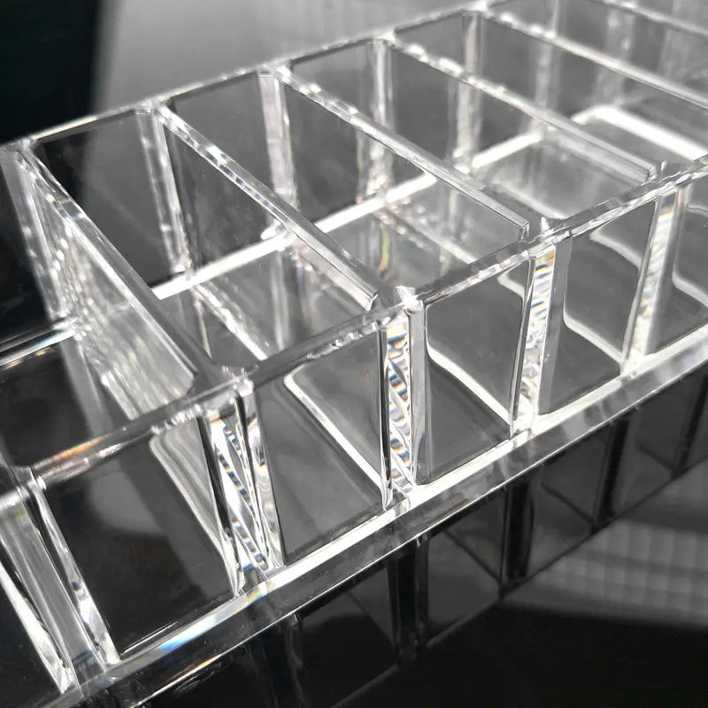 clear acrylic makeup organizer with a grid of rectangular compartments shown in a makeup organizer image for efficient cosmetic storage.