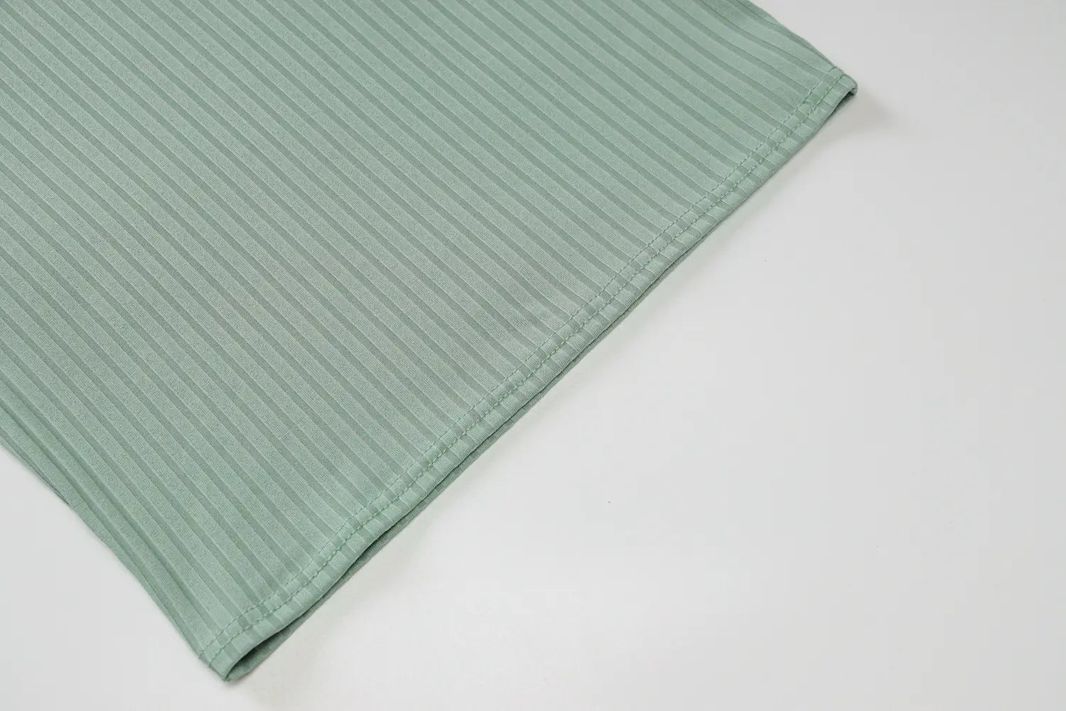 a soft mint green ribbed fabric with subtle vertical texture and neatly stitched edges of a knitted women sleeveless olive green stripe knitted dress