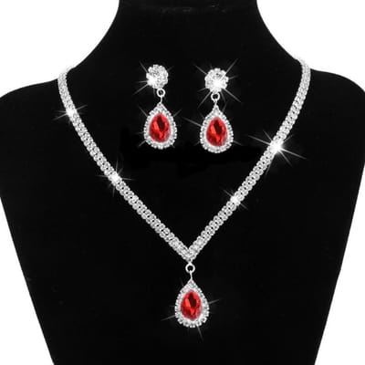 silver v-shaped crystal bridal jewelry set featuring red teardrop-shaped crystal earrings and matching necklace with silver-toned chains adorned with sparkling rhinestones for elegant bridal jewelry.