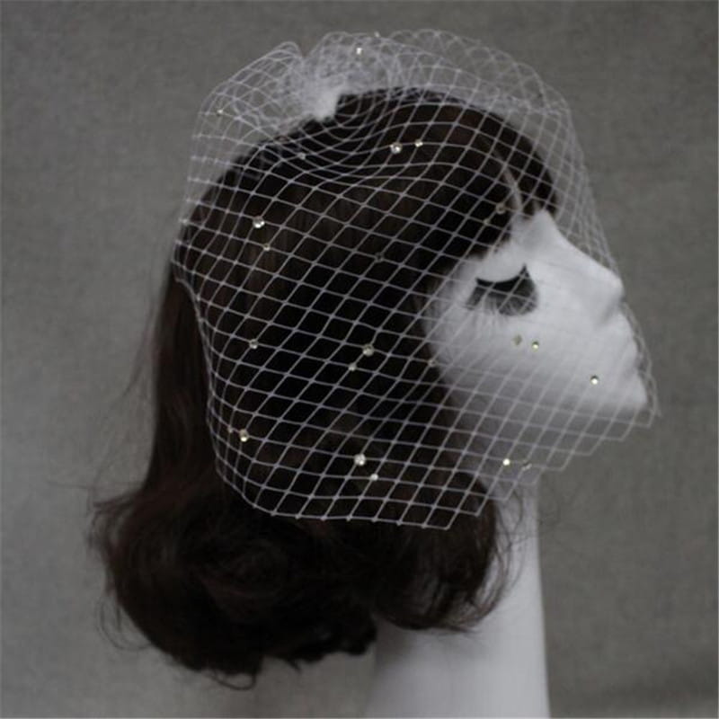 a delicate white bridal veil rhinestone large hole mesh headdress adorned with scattered sparkling rhinestones elegantly draped over a mannequin head