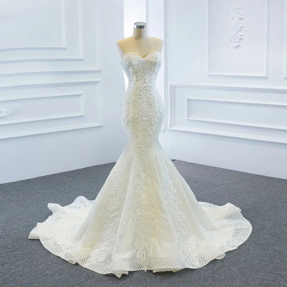 A white lace mermaid wedding dress wears two fishtail train with intricate floral embroidery and a fitted bodice.