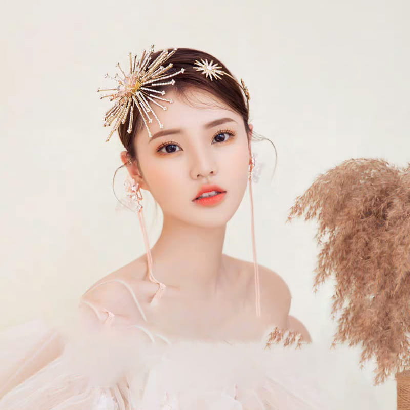 A delicate silver starburst bridal rhinestone headband with intricate metalwork and sparkling rhinestones is an elegant hair accessory perfect for weddings.