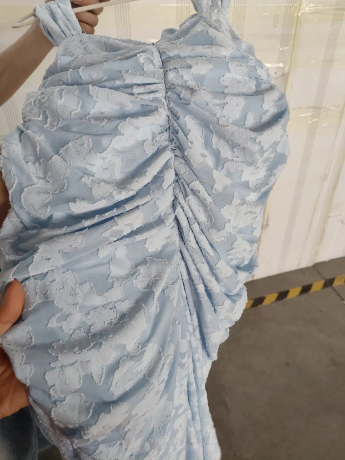 A light blue ruched bodycon dress with floral pattern and gathered fabric ideal as a backless sexy evening dress.