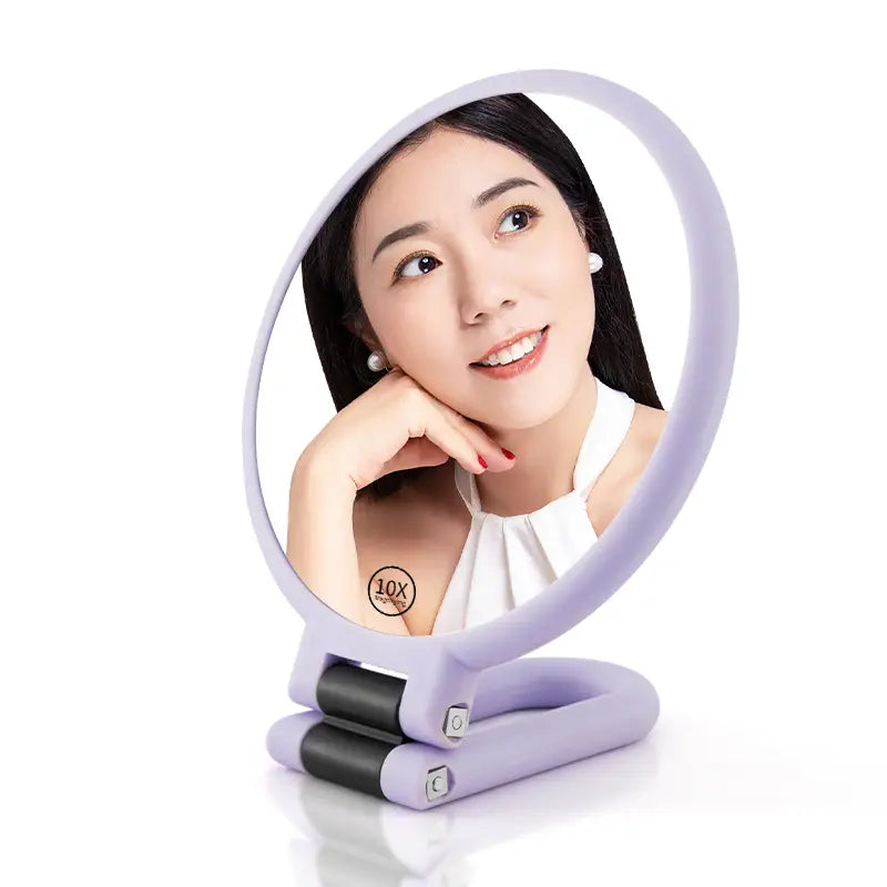 A lavender-colored handle mirror purple with 10x magnification featuring a sleek foldable design and black hinge accents.