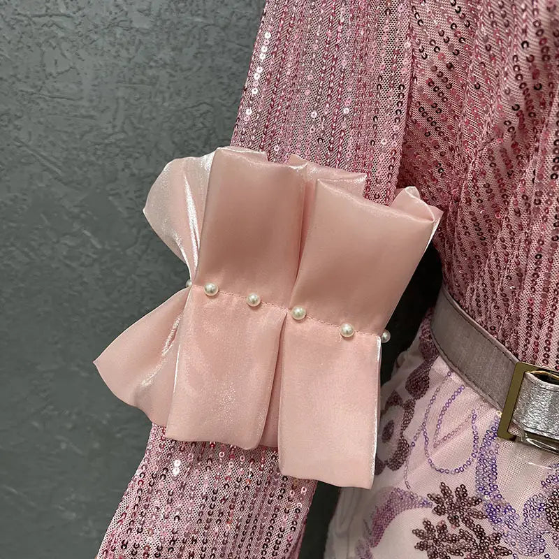 a delicate pink satin bow with pearl accents adorns the sleeve of a sequined round neck half sleeve slim fit floral evening dress
