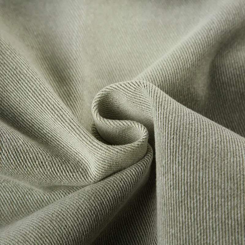 light green jeans double belt adjustable buckle shorts made of soft muted olive-green denim fabric with subtle diagonal ribbed texture.