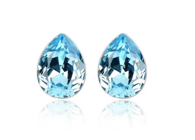A pair of elegant pear-shaped blue topaz stud earrings with a faceted cut in a silver-toned creative alloy jewelry setting from a blue crystal alloy jewelry set necklace.