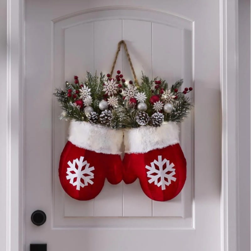 red and white christmas mittens decorated with snowflakes filled with festive greenery red berries silver ornaments and pinecones in a christmas garland creative glove shaped wreath