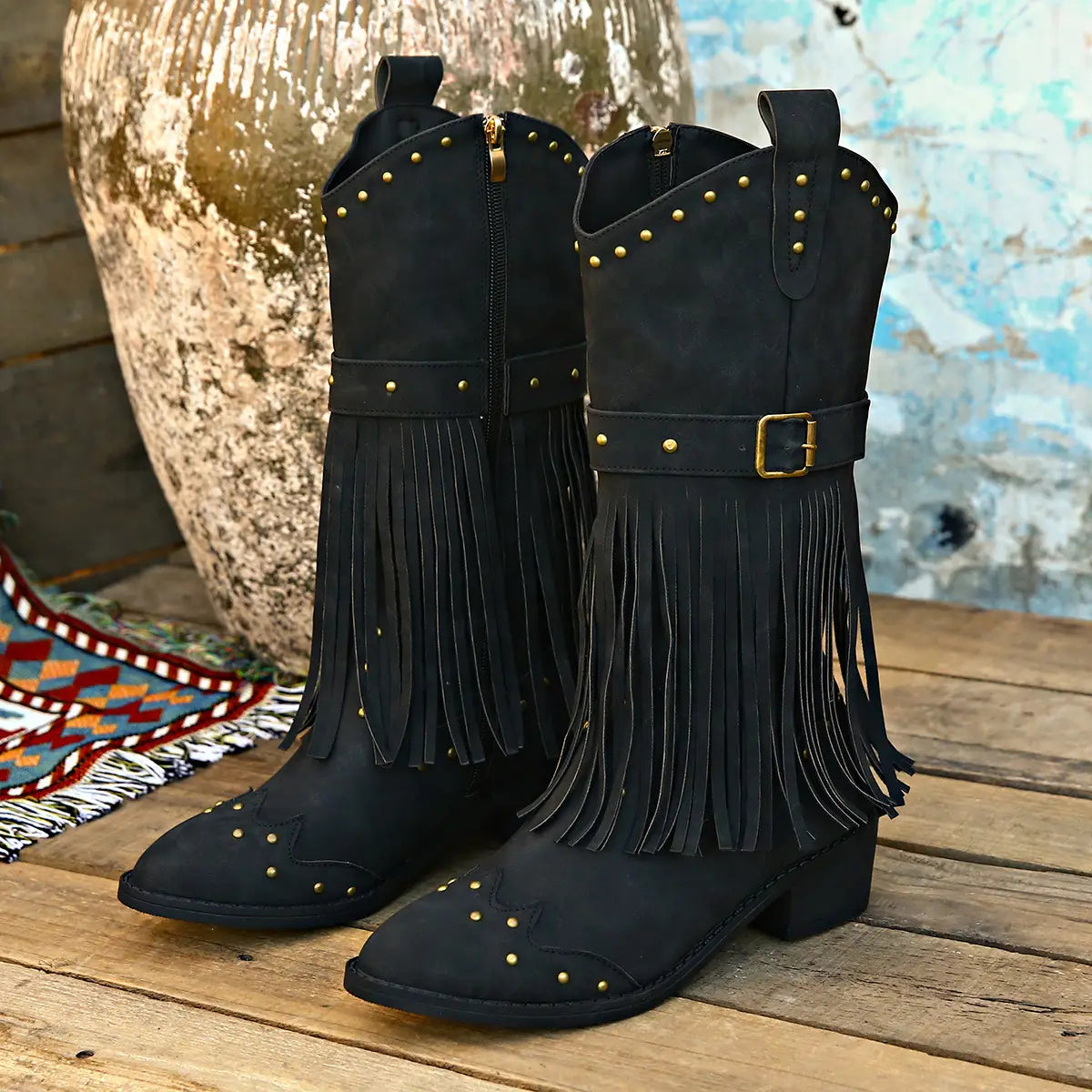 black suede cowboy boots featuring gold-tone studs a decorative belt buckle and fringe detailing ideal for retro winter fashion with a fashion square heel