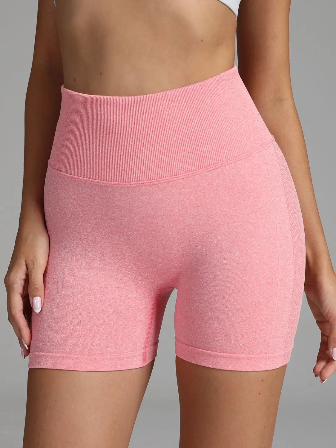 Pink high waist seamless yoga shorts for women featuring a solid color design with a ribbed waistband and textured fabric.