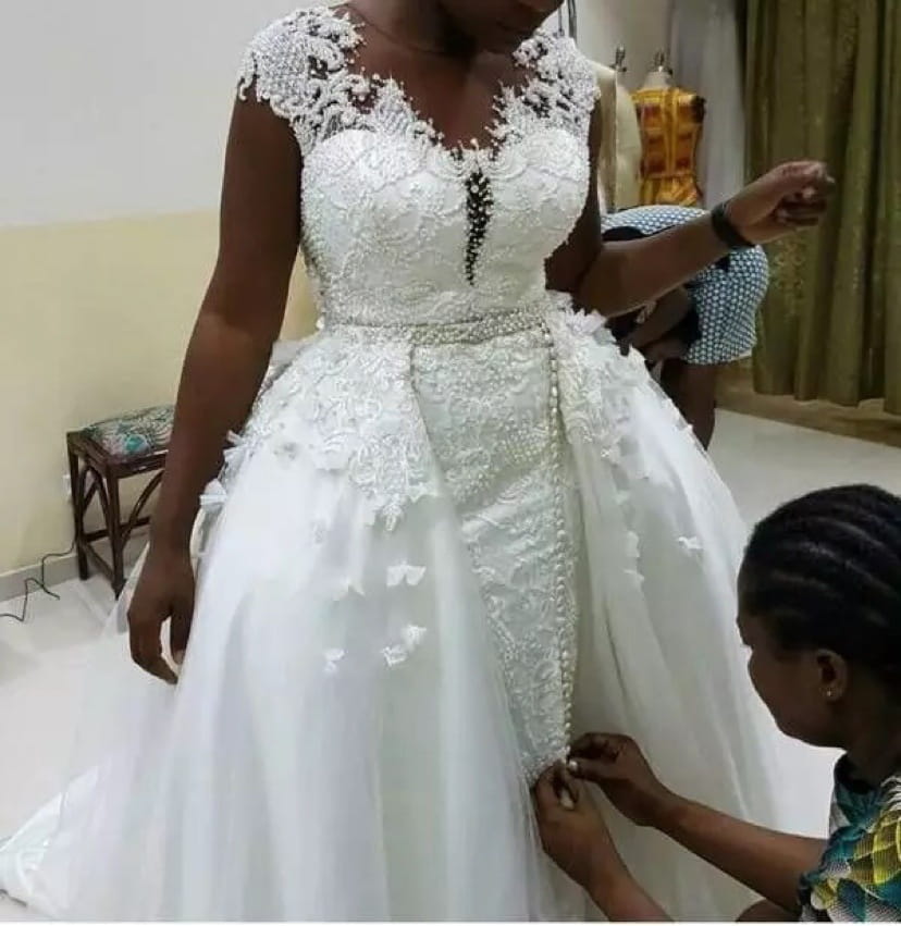 a white lace african mermaid detachable wedding dress featuring intricate beading and a fitted bodice