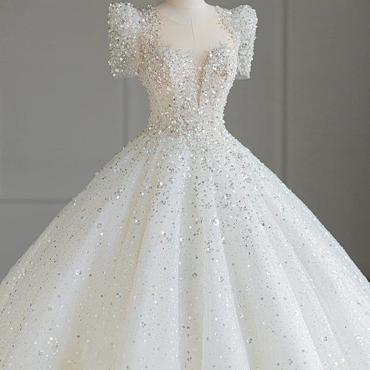 A sparkling beaded white wedding dress with short puffed sleeves and a voluminous tulle skirt featuring intricate silver beading, ideal as a floral wedding dress.