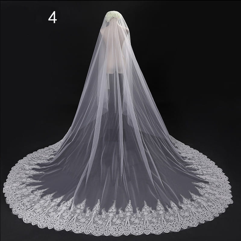 a delicate white lace bridal veil with an intricate floral pattern along its scalloped edge in a long lace wedding veil meters wide style