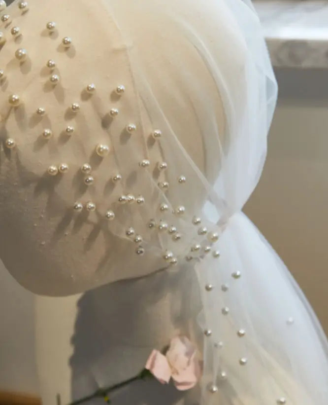 a delicate ivory tulle super fairy long pearl veil bridal hijab adorned with scattered silver beads and a soft pink rose accent