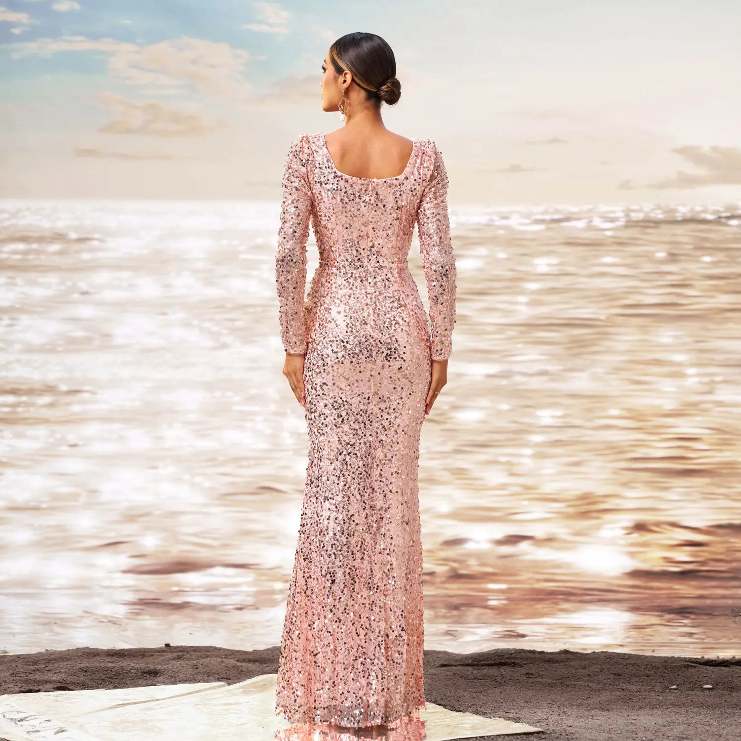 A shimmering pink long sleeve sequined sheath fishtail evening dress with a floor-length hem and square neckline.