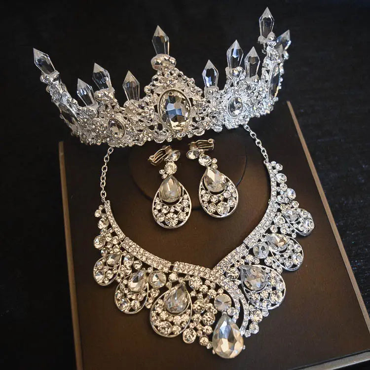 Silver crystal bridal headdress flowers set featuring clear crystal spikes, a central oval gemstone, and matching drop earrings with an ornate necklace including teardrop crystals, ideal for headdress flowers wedding or flowers wedding hair styles.
