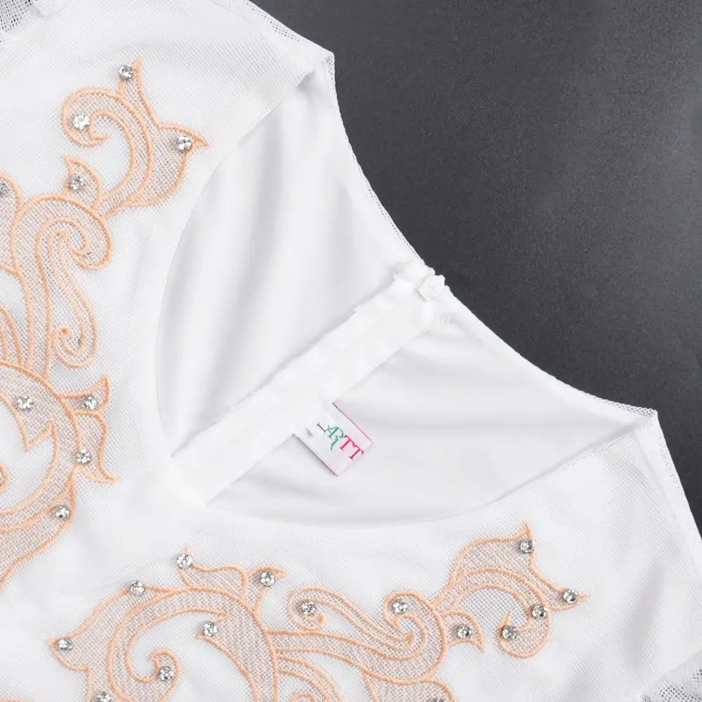 Luxury rhinestone beaded white dress with delicate peach-colored lace embroidery and sparkling rhinestones along the neckline for formal occasions.