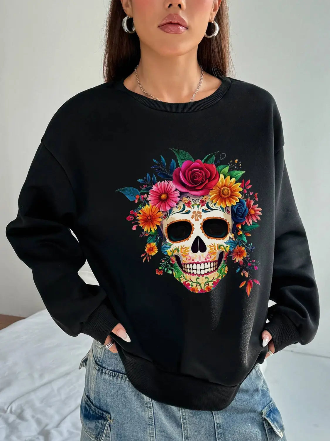 Black crew neck sweatshirt for daily wear featuring a vibrant colorful floral skull design on the front with basic long sleeve style.
