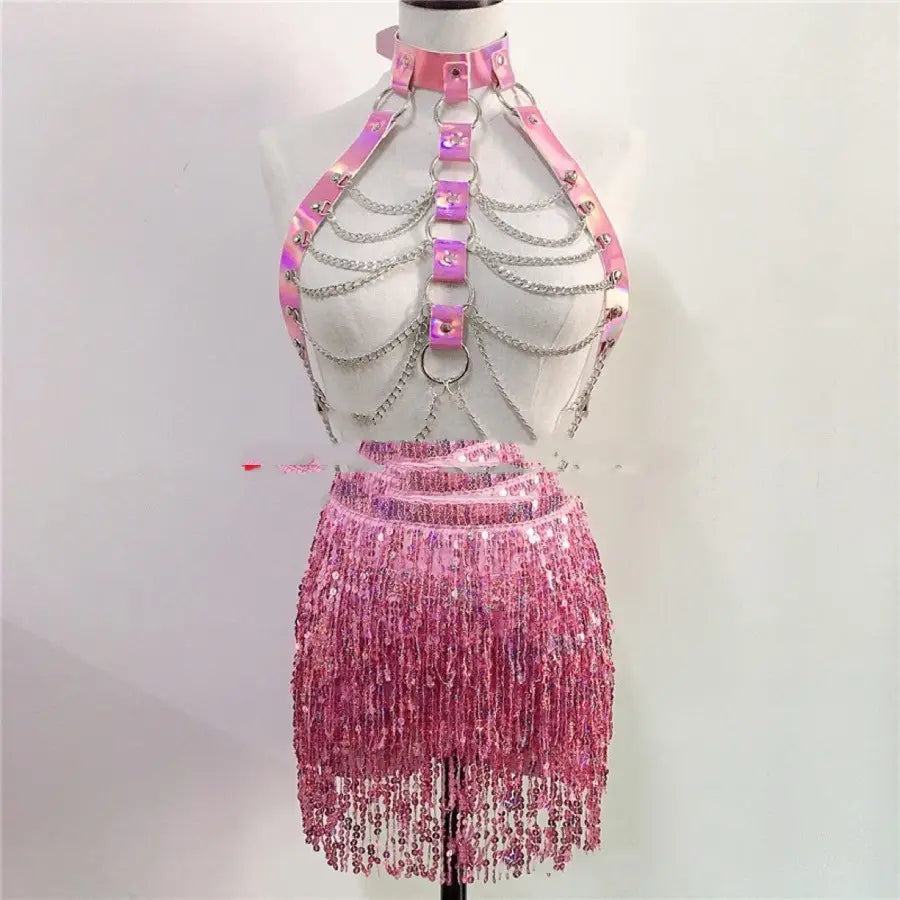woman wearing a pink holographic sequin fringe skirt with matching metallic chain and leather harness top designed as a night club stage dress ideal for club stage dress and stage dress woman use