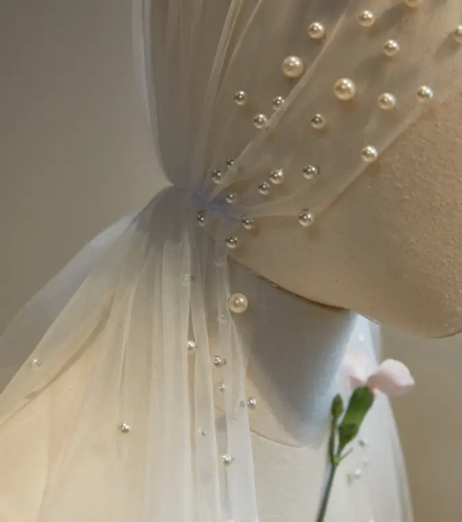 a delicate white tulle super fairy long pearl veil bridal hijab adorned with scattered pearls and silver beads