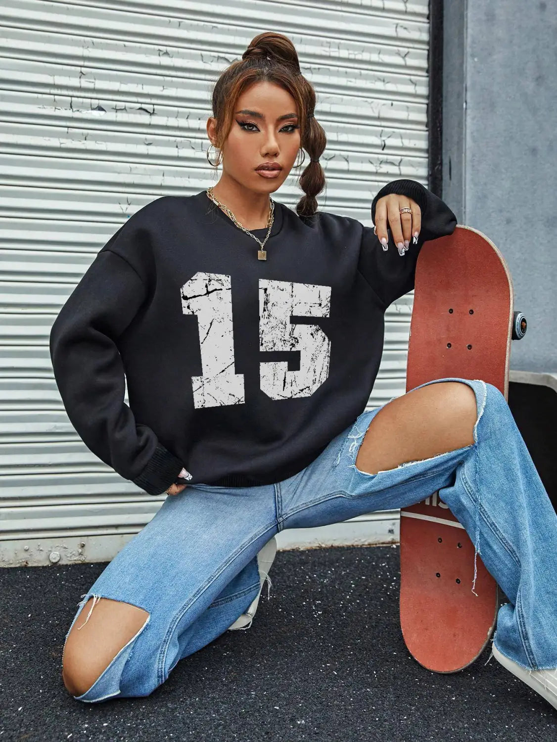 Black oversized crew neck sweatshirt featuring a distressed white number 15 graphic on the front