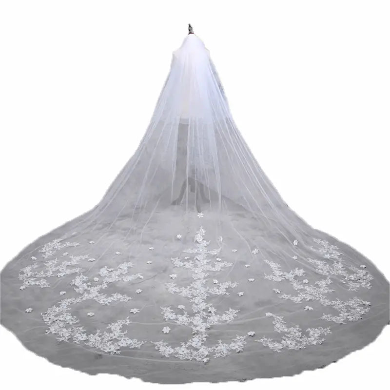 A delicate white lace wide style bridal wedding dress veil with intricate floral embroidery and attached hair comb.