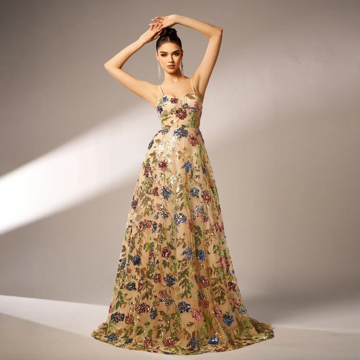 an elegant sleeveless sequined suspender evening dress in champagne color featuring intricate blue red and green floral embroidery with flowing fabric