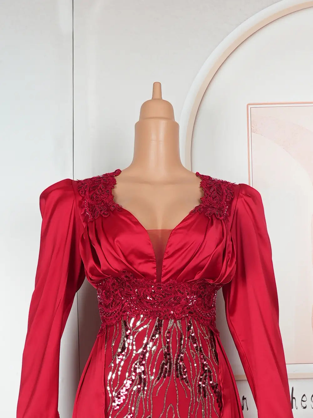 A vibrant red satin plus size long sleeve sequined evening dress featuring intricate lace detailing at the neckline and waist with shimmering sequin embellishments along the bodice.