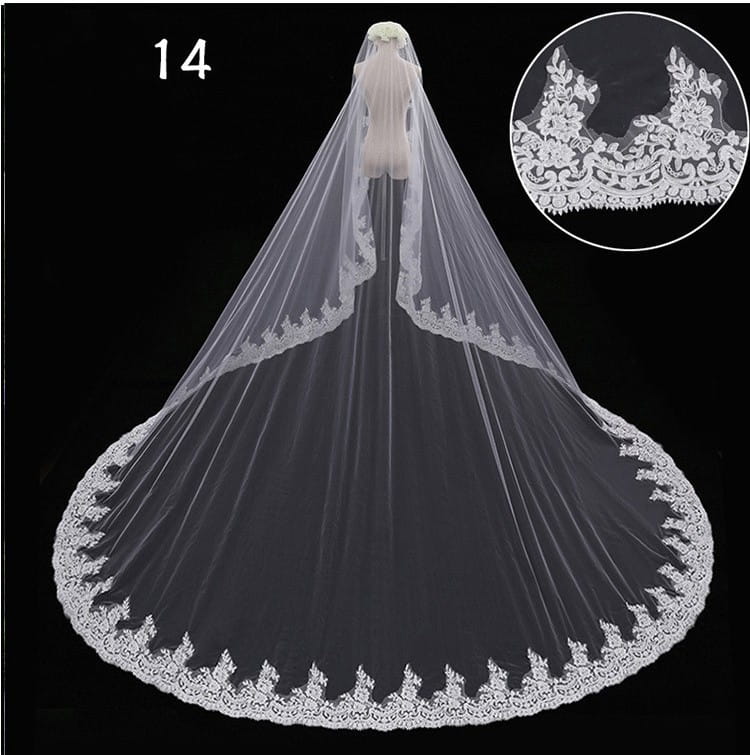 A long flowing white lace veil with intricate floral embroidery along the edges featuring a wide style and hair comb for a bridal wedding dress.