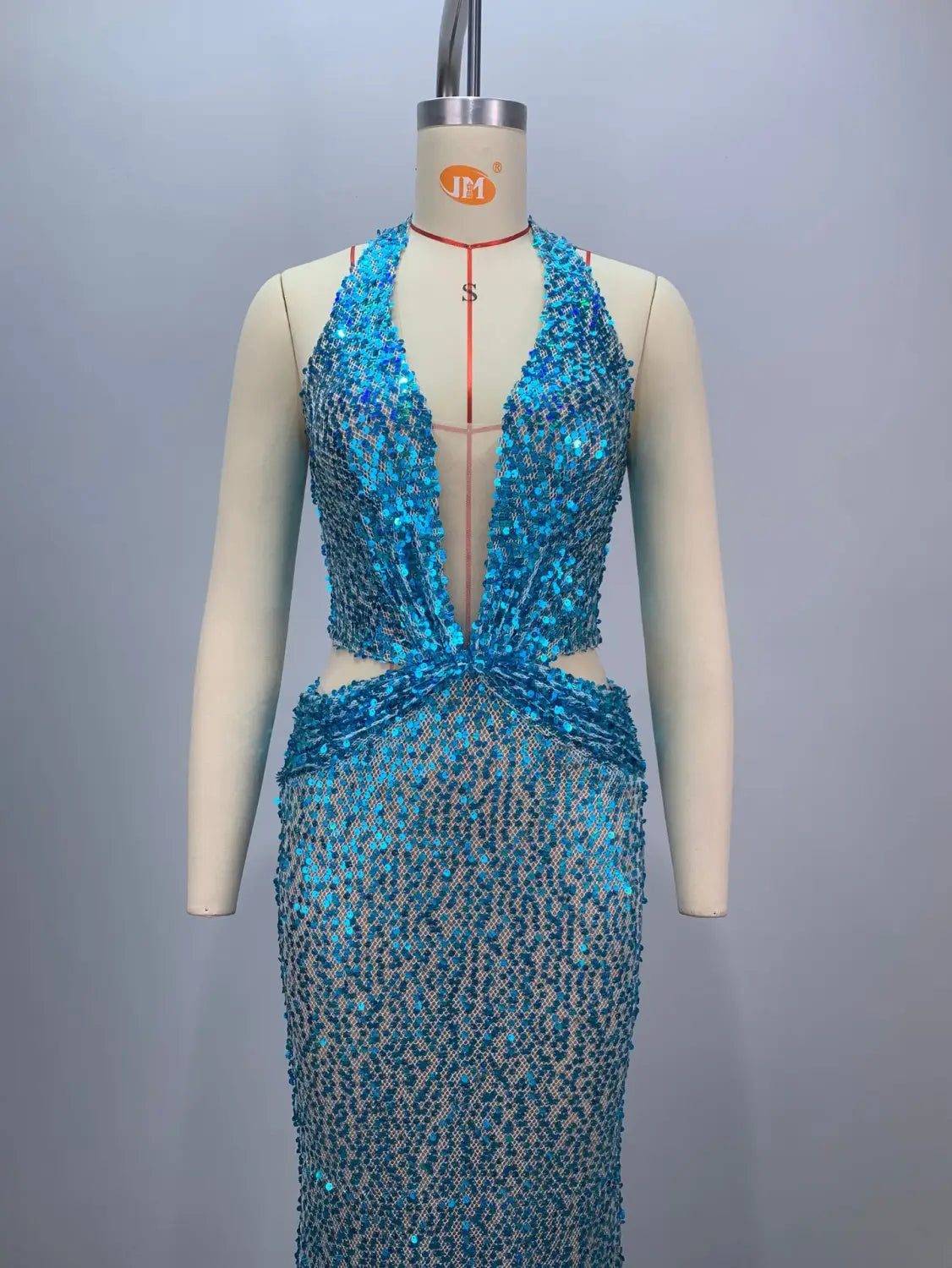 a shimmering turquoise sequined halter-neck mermaid gown with a plunging neckline and cinched waist displayed on a mannequin designed for a slimming party stage host.
