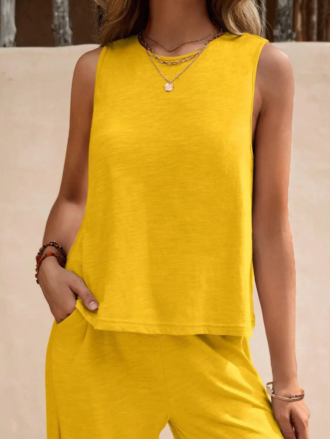 bright yellow sleeveless top with a relaxed fit and soft lightweight fabric paired with black casual loose pants in a casual loose pants set