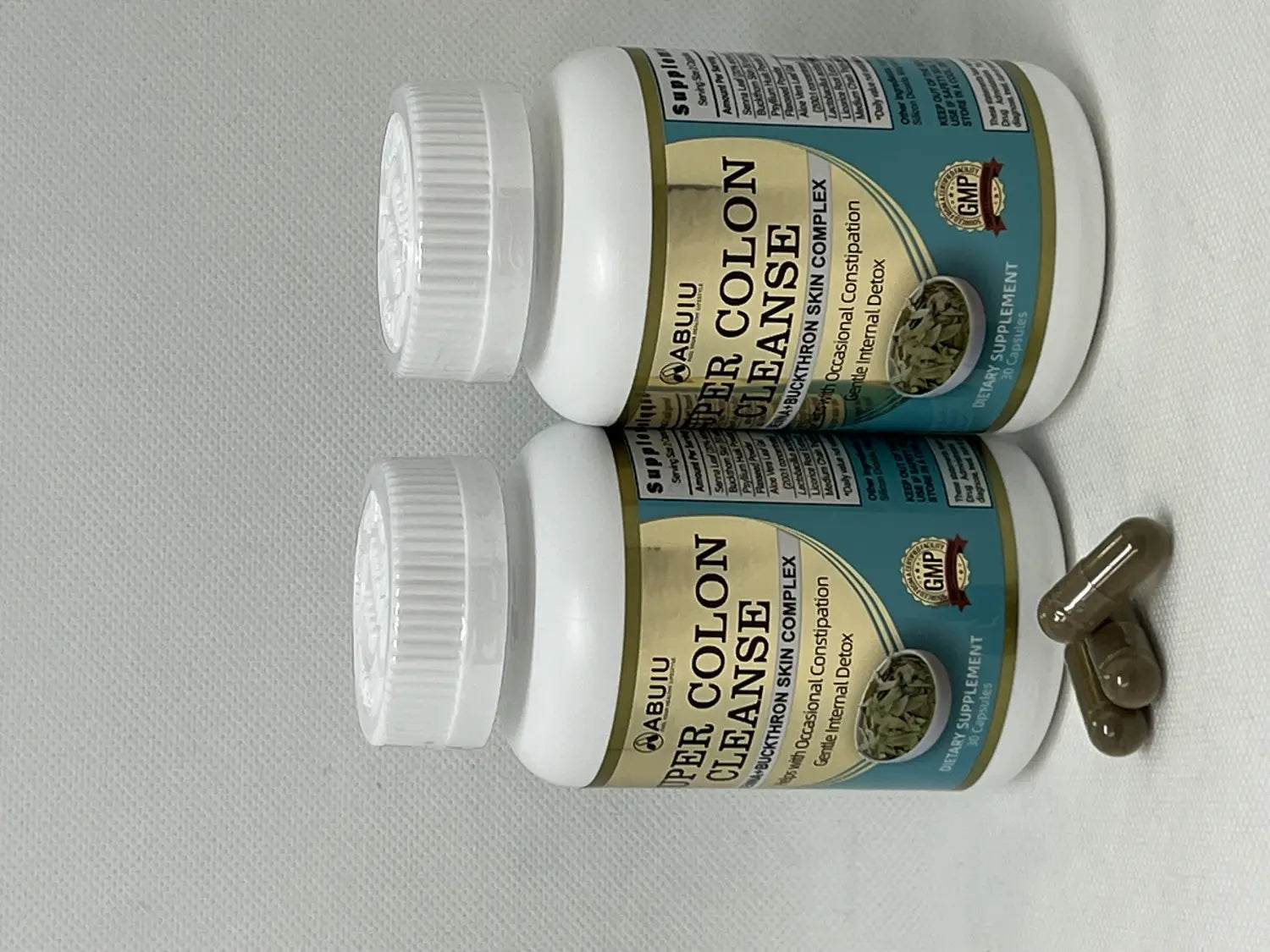 Two white plastic bottles of abuiu super colon cleanse dietary supplement with teal and gold labels showing the brand name and product description for cleanse capsule 30 count.