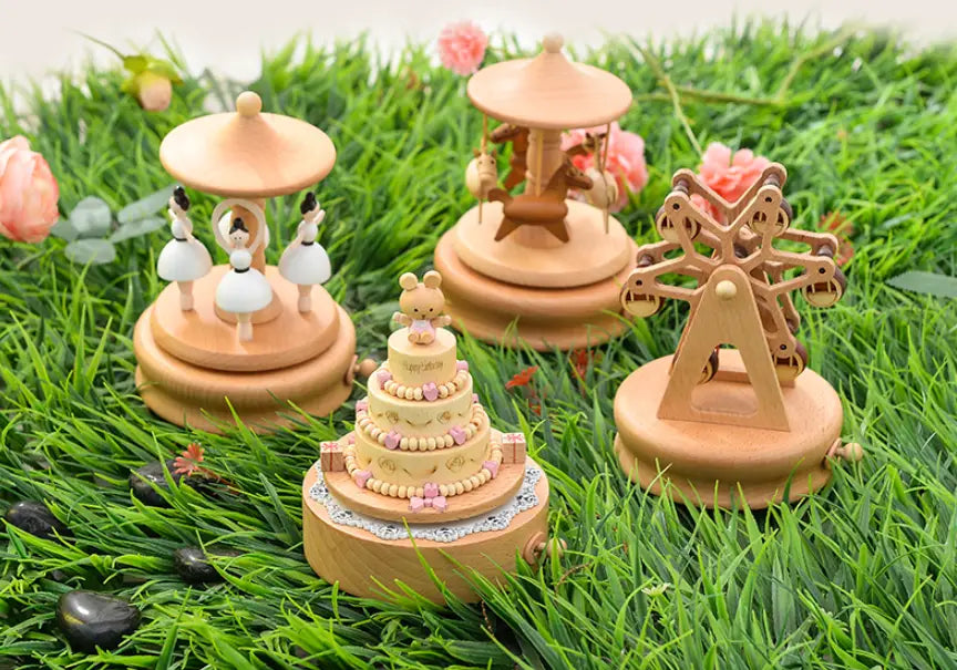 wooden rotating music box featuring miniature dancers and a central cake topper designed as a wedding rocking horse.
