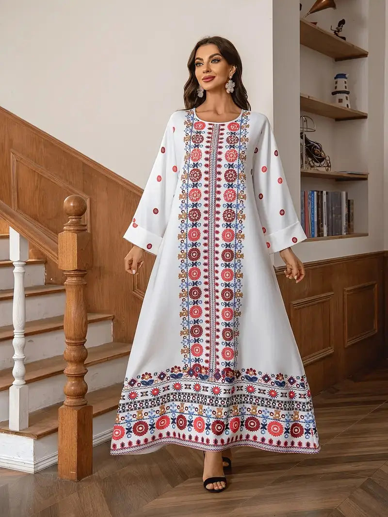 White long sleeve embroidered rhinestone bead maxi dress featuring intricate red blue and gold floral print along the front panel and hem.