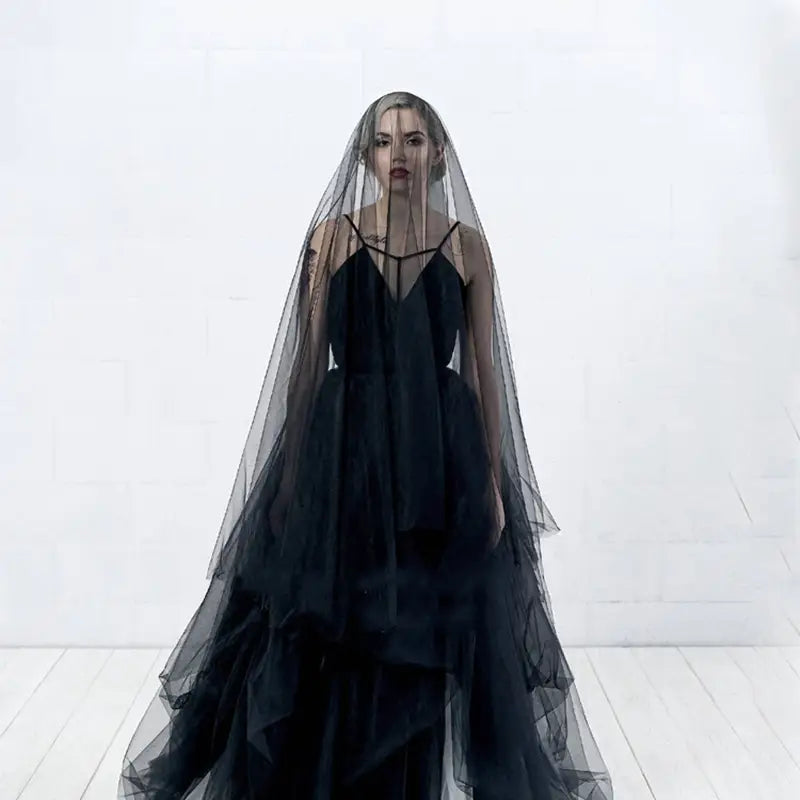 a flowing black tulle wedding black veil with a sheer layered design drapes elegantly over the bride wedding shoulders and head