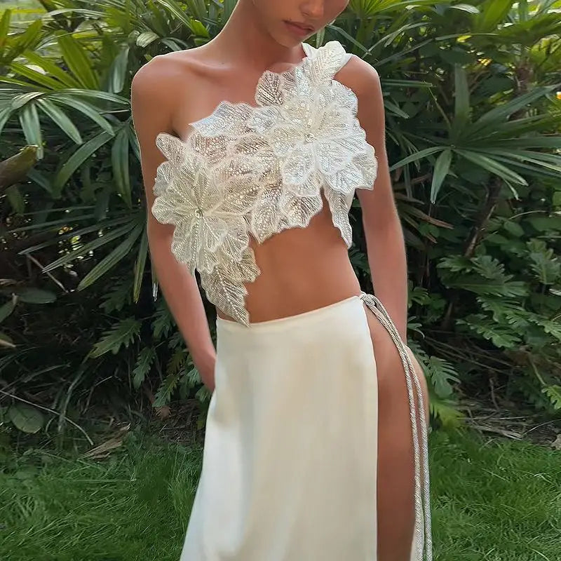 a white lace floral crop top with intricate detailing paired with a satin split skirt featuring side ties in a backless sequined lace skirt suit