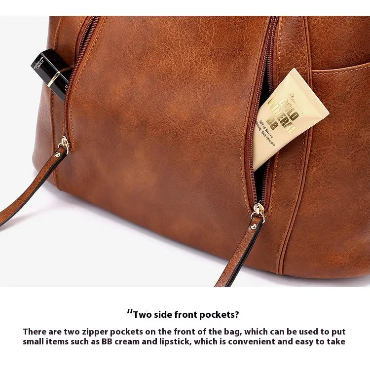 Brown leather backpack featuring two zipper front pockets designed as a large capacity luxury women leather hobo bag.