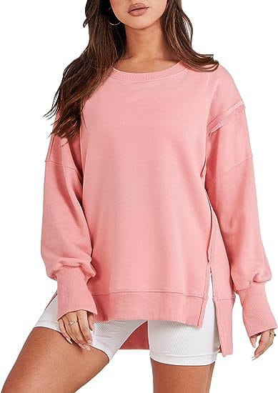 Pink solid oversized sweatshirt with a relaxed fit featuring a crew neck and side slit detail for casual wear